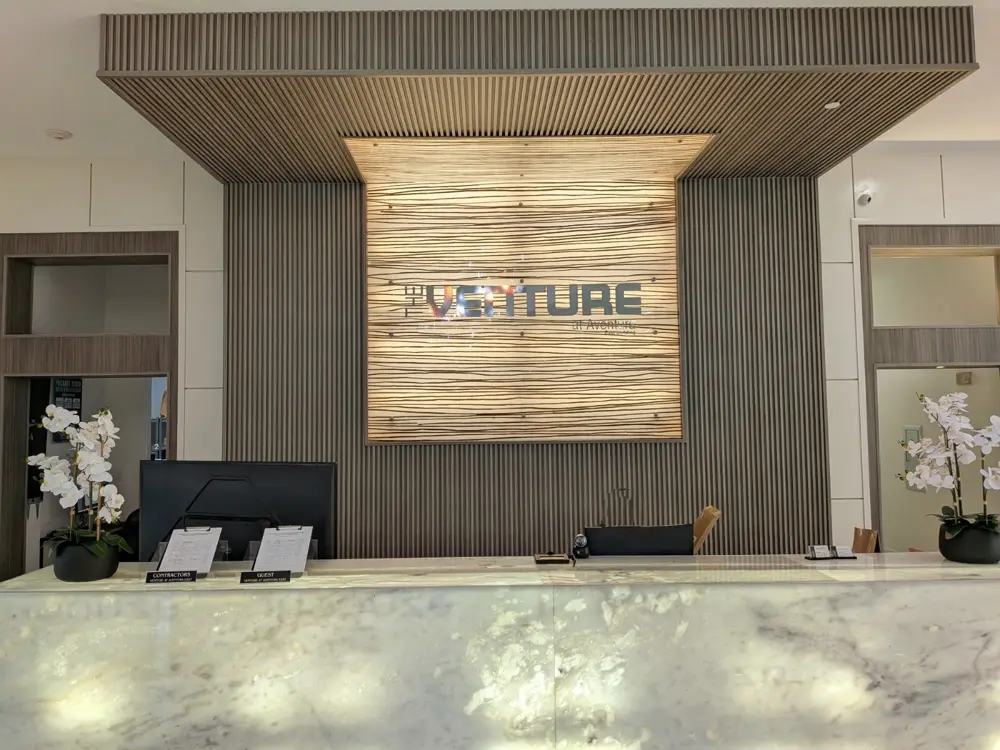 Attended East tower front desk with backlit wall and The Venture sign