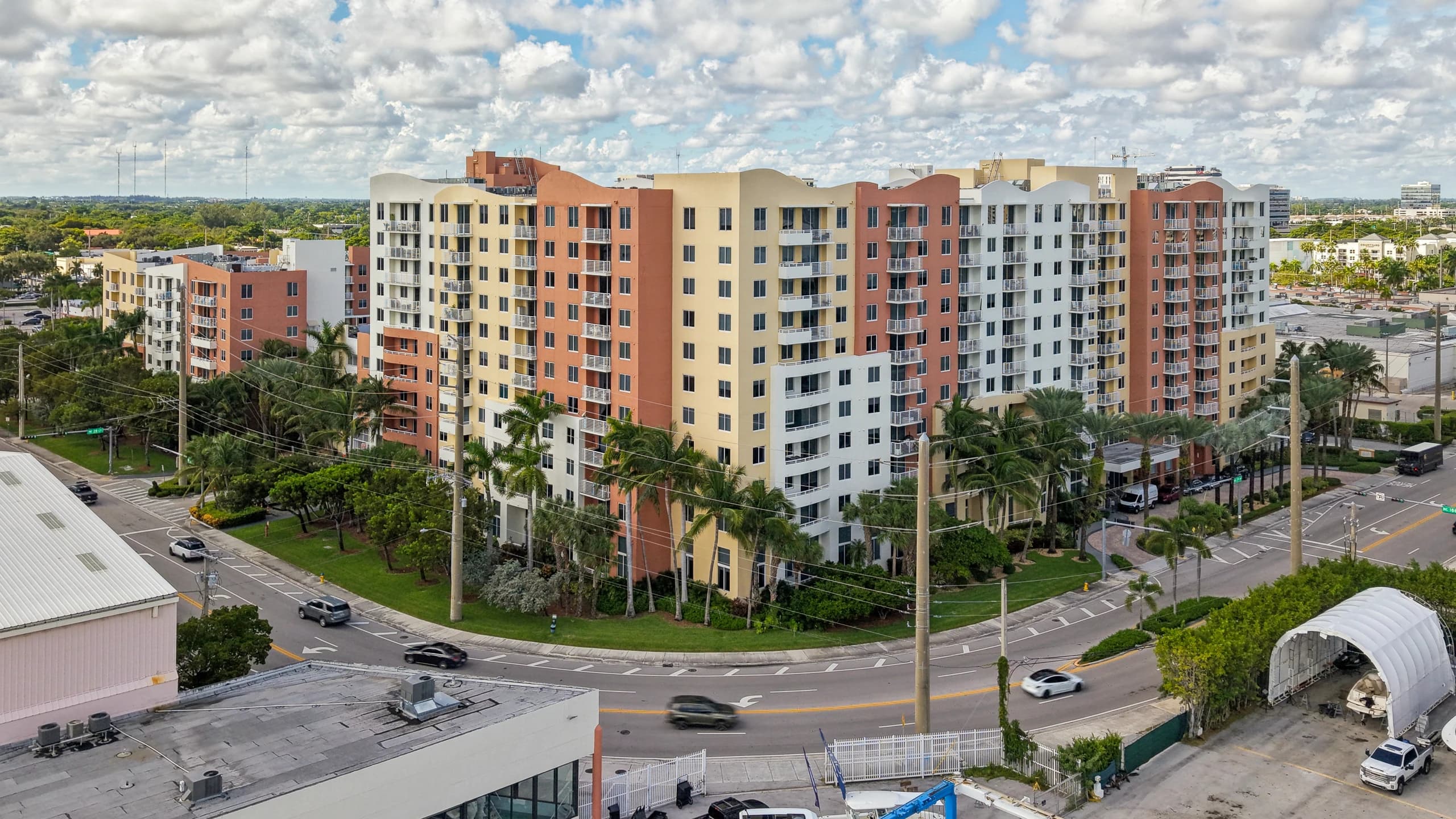 The Venture at Aventura East tower, an 11-story coral, yellow and white building on a curved corner lot