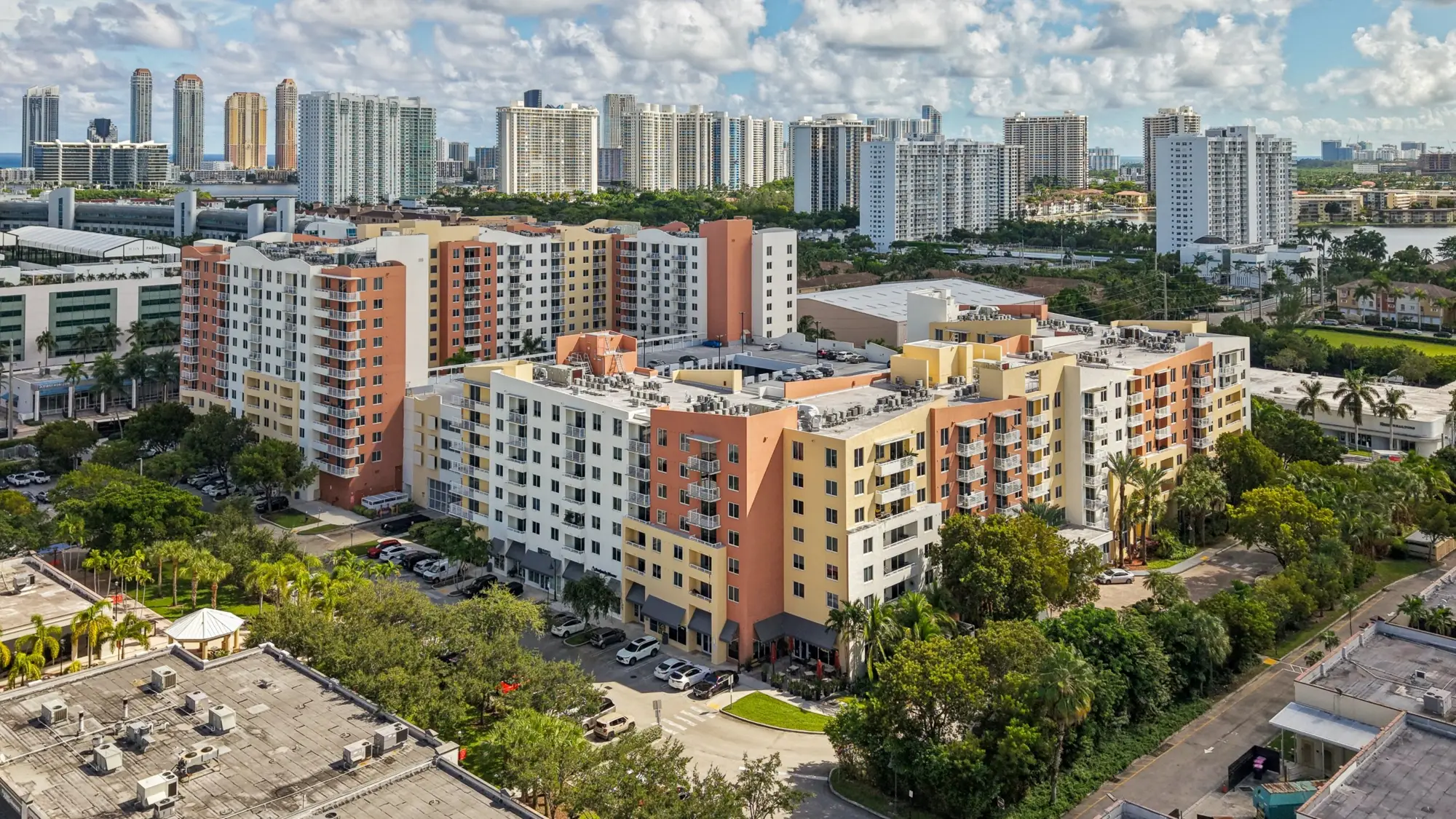 Both towers of The Venture at Aventura with the Sunny Isles Beach skyline behind