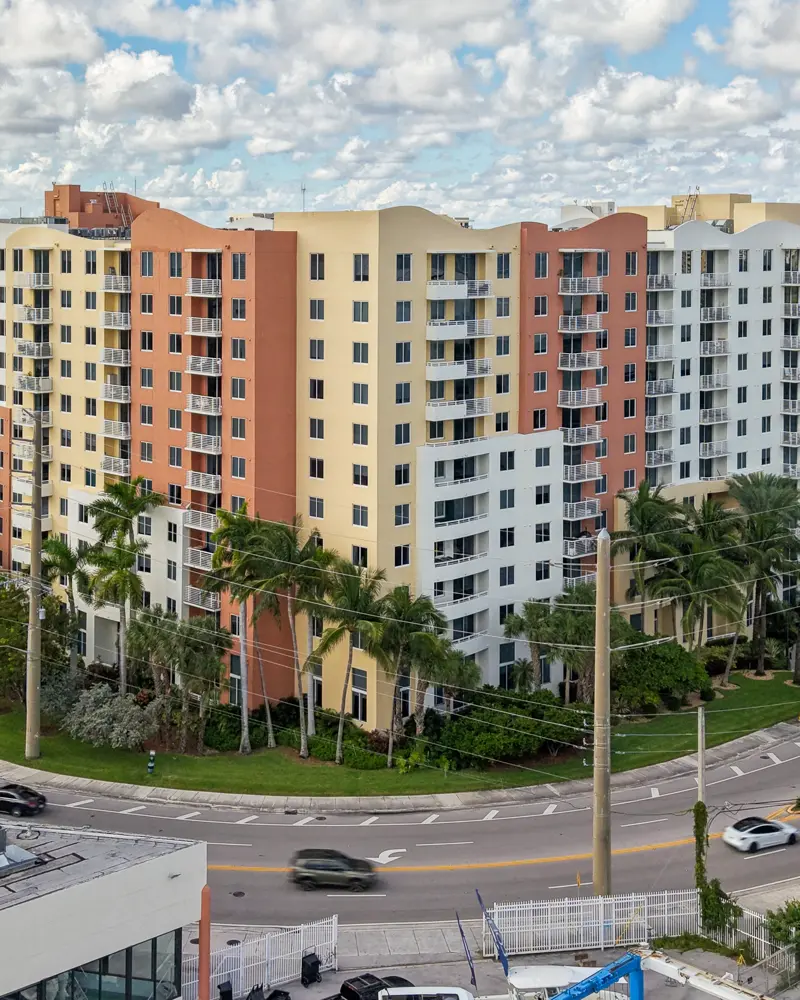 The Venture at Aventura East tower, an 11-story coral, yellow and white building on a curved corner lot